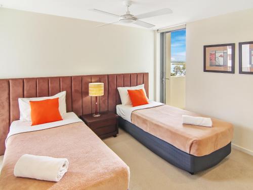 a bedroom with two beds and a window at Space Holiday Apartments in Maroochydore