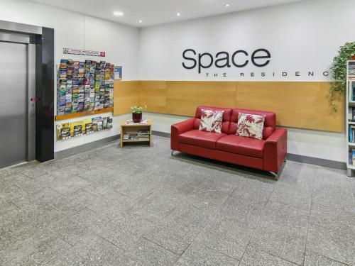 a red couch in the lobby of a store at Space Holiday Apartments in Maroochydore