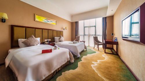Changsha Jiaxing Inn في تشانغشا: غرفة فندقية بسريرين ومكتب