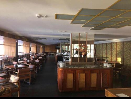 un restaurante con bar, mesas y sillas en Sian Apart Hotel Garvey, en Brasilia