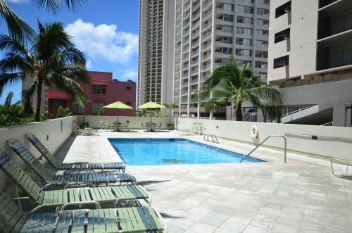 una piscina con sedie a sdraio accanto a un edificio di Waikiki Park Heights 1208 Sun & Beach Fun only 3 minutes away a Honolulu
