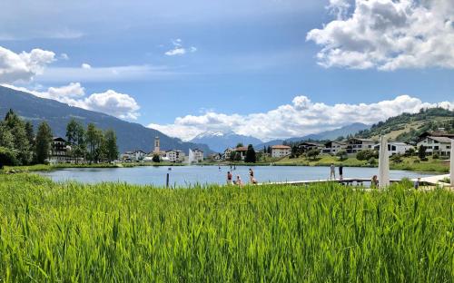 a body of water with people standing on a dock at Rancho Laaxdeluxe in Laax