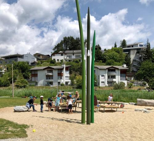 a group of people sitting at picnic tables in a park at Rancho Laaxdeluxe in Laax