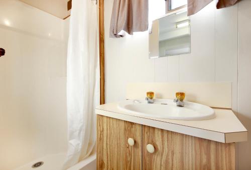 a bathroom with a white sink and a shower at Tasman Holiday Parks - Serpentine Falls in Serpentine