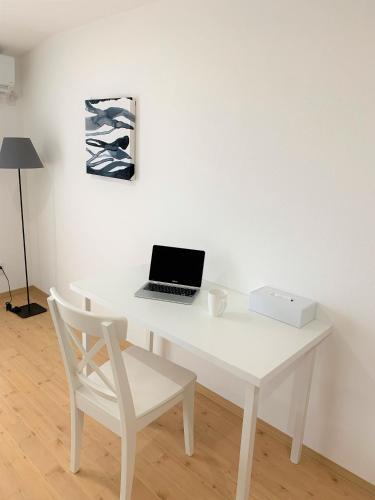 a white desk with a laptop and a chair at Hotel Miyakojima in Miyako Island