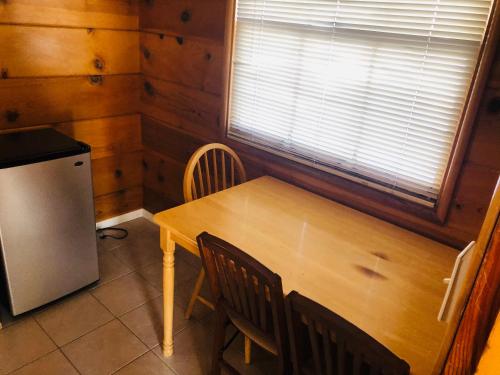 a dining room with a wooden table and a refrigerator at Mountain View Cabins in Wrightwood