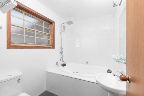 a bathroom with a sink, toilet and tub at Yarra Valley Motel in Lilydale