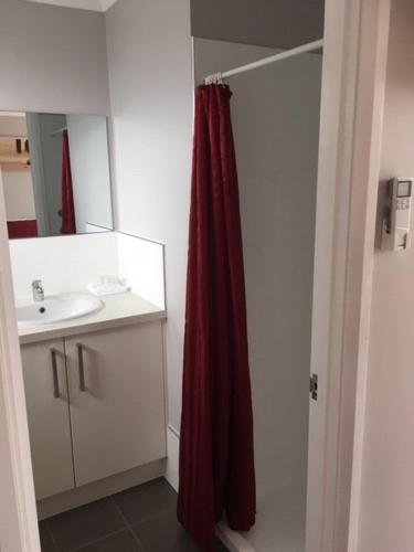 a bathroom with a red shower curtain next to a sink at Border Village Roadhouse in Border Village