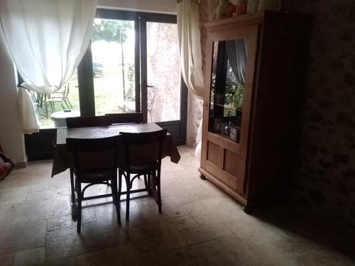 d'une salle à manger avec une table, des chaises et une fenêtre. dans l'établissement Studio indépendant dans Ferme Equestre, à Aups