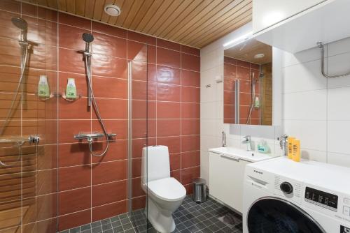 uma casa de banho com um WC, um lavatório e uma máquina de lavar roupa em Riverside Lux with 2 bedrooms, Car Park garage and Sauna em Turku