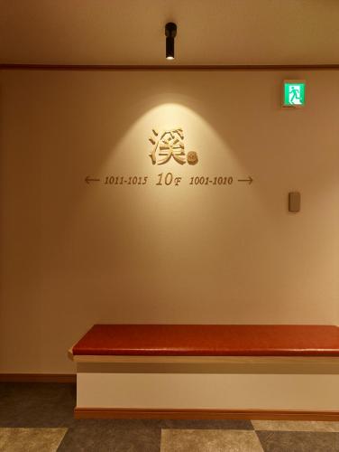 a bench in a room with a sign on the wall at Saito Hotel in Ueda