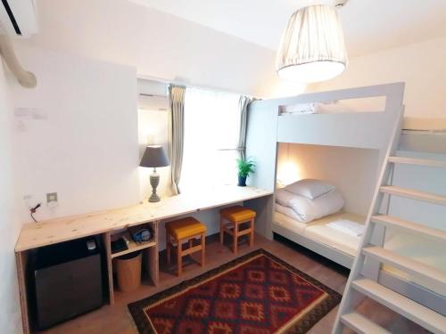 a small room with a desk and a bunk bed at Ten to Sen Guesthouse in Takamatsu