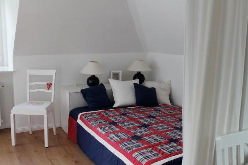 a bedroom with a bed and a table and two lamps at Seeblick in Westensee