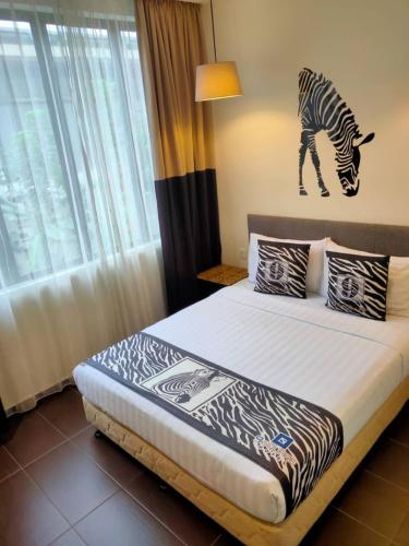 a bedroom with a bed with a zebra picture on the wall at 9 Square Hotel - Subang in Subang Jaya