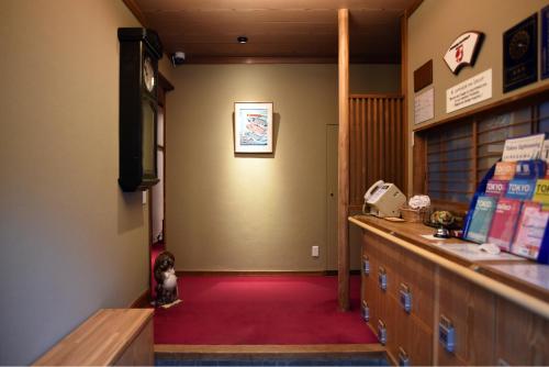 una sala de espera con un mostrador y una alfombra roja en Ryokan Sansuiso, en Tokio