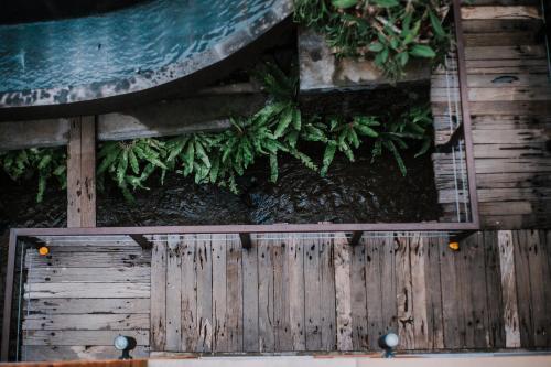 a wooden fence with plants on top of it at Merak Village by Prasi in Ubud
