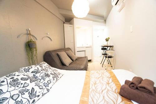 東京にあるHill Side Terrace Hiroo Shibuya 203のベッドとソファのある寝室