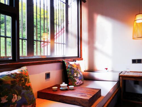 a living room with a bench with a wooden table at 武当山太和紫隐酒店 in Wudangshan