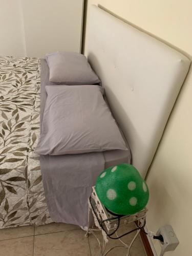 a small bed with a green helmet next to it at Bicocca Flat F in Milan
