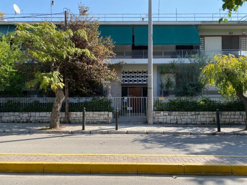 a building with a tree in front of a street at Renovated apartment in Kifissia Center near Metro G25 in Athens