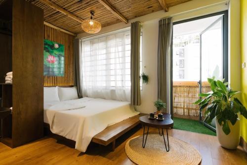 a bedroom with a bed and a large window at The Autumn Homestel in Hanoi