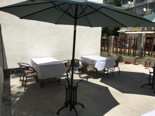 two tables and chairs under an umbrella on a patio at Sofia Family House - Free Parking in Sofia