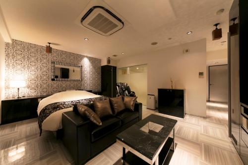 a bedroom with a bed and a couch and a fireplace at HOTEL ELDIA (Adult Only) in Gyōda