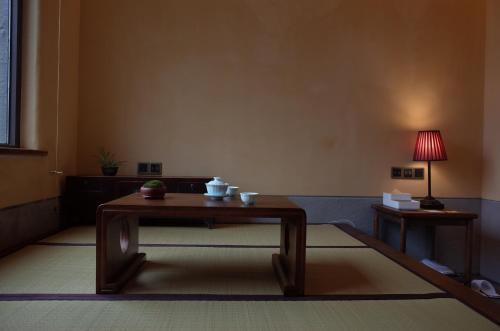 a living room with a table and a lamp at 武当山太和紫隐酒店 in Wudangshan