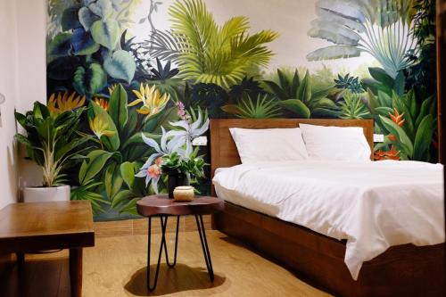 a bedroom with a bed and a painting of plants at The Autumn Homestel in Hanoi