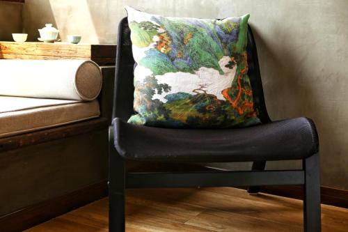 a chair with a pillow on top of it at 武当山太和紫隐酒店 in Wudangshan