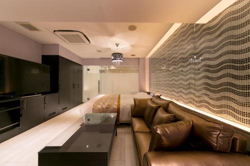 a living room with a couch and a flat screen tv at HOTEL ELDIA (Adult Only) in Gyōda
