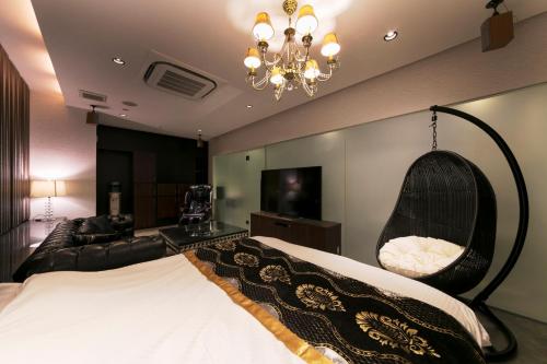 a bedroom with a large bed and a chandelier at HOTEL ELDIA (Adult Only) in Gyōda