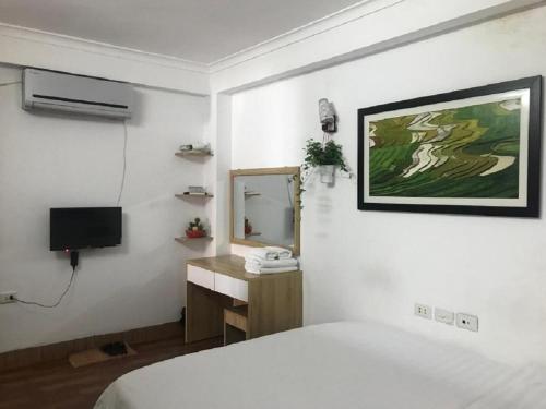 a bedroom with a bed and a sink and a mirror at The Autumn Homestel in Hanoi