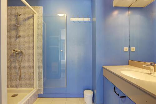 une salle de bain bleue avec une douche et un lavabo dans l'établissement villa 8 pers, climatisée, piscine chauffée, un havre de paix sous les pins parasols, à Roquebrune-sur Argens