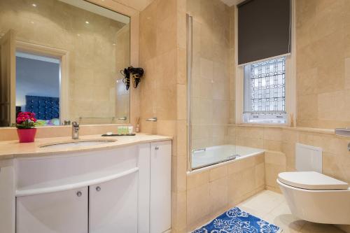 a bathroom with a sink and a toilet and a tub at Apartment on Duke Street in London