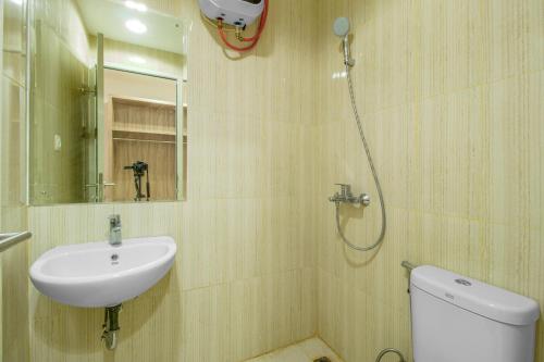 een badkamer met een wastafel, een toilet en een douche bij Skyland Sentul Tower Apartment in Bogor