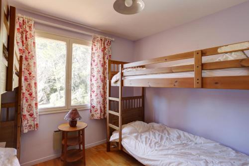 une chambre avec deux lits superposés et une fenêtre dans l'établissement villa 8 pers, climatisée, piscine chauffée, un havre de paix sous les pins parasols, à Roquebrune-sur Argens