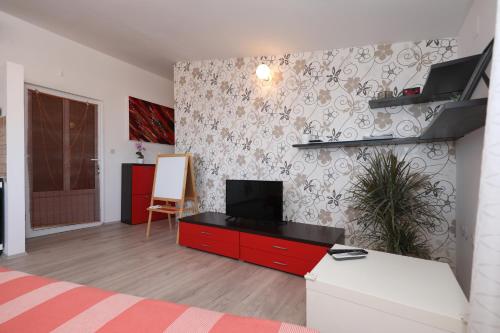 a living room with a bed and a tv on a wall at Apartment Zanov in Preko