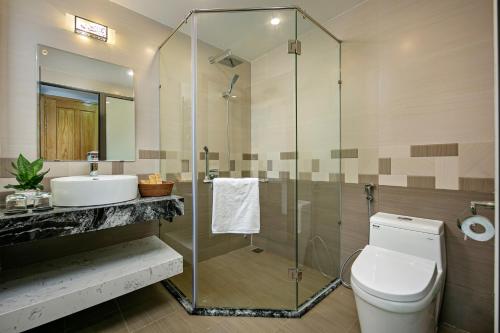ein Bad mit einer Dusche, einem WC und einem Waschbecken in der Unterkunft Villa Blake Hoi An in Hoi An
