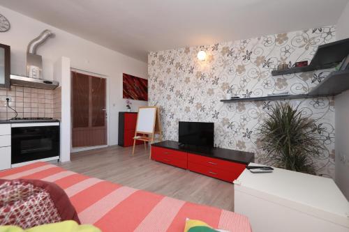 a living room with a red cabinet with a television at Apartment Zanov in Preko