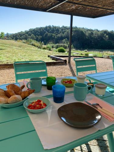 Una mesa con pan y un plato de comida sobre ella. en Chut ! c'est ici, en Venelles