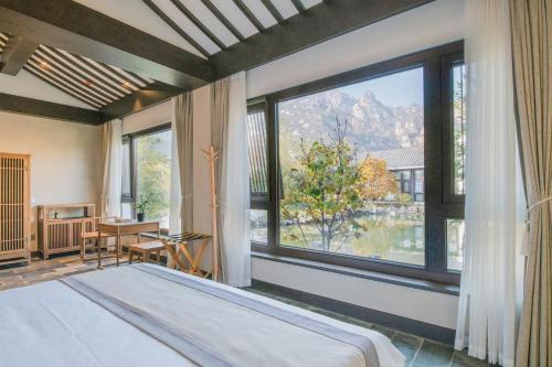ein Schlafzimmer mit einem Bett und einem großen Fenster in der Unterkunft Guan Sam Hotel in Peking
