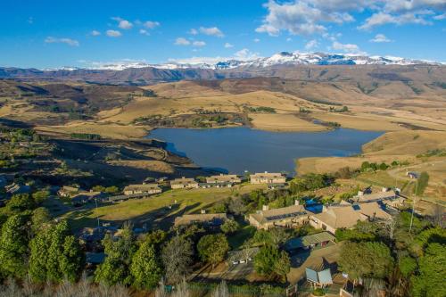 einem Luftblick auf ein Dorf mit See und Bergen in der Unterkunft Cayley Mountain Resort in Champagne Valley