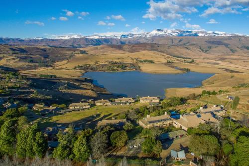 an aerial view of a village with a lake and mountains at Cayley Mountain Resort in Champagne Valley