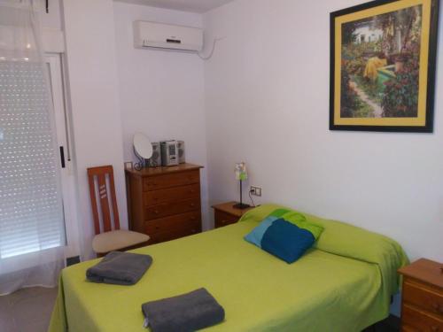 1 dormitorio con 1 cama verde y 2 almohadas en Huéznar Rural en San Nicolás del Puerto