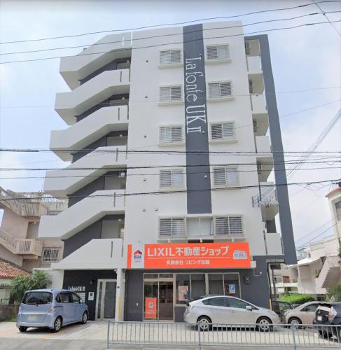 a building with cars parked in front of it at La Fonte UK2 in Ginowan