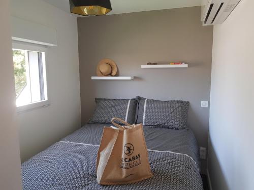 ein Zimmer mit einem Bett mit einer Tasche darauf in der Unterkunft Studio de Lokentaz in Saint-Gildas-de-Rhuys