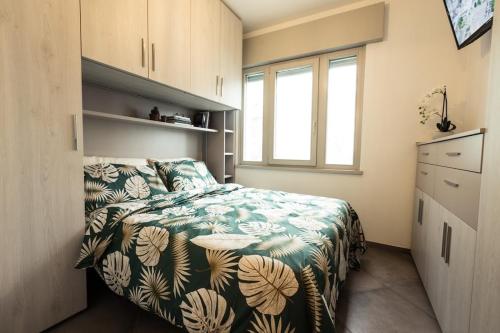 um quarto com uma cama com um cobertor verde e branco em Cattleya em Grado