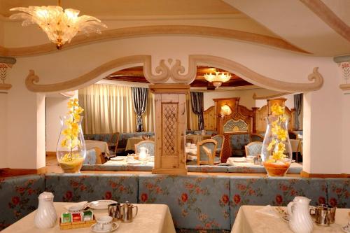 a dining room with two tables and two vases at Kristiania Pure Nature Hotel & Spa in Cogolo