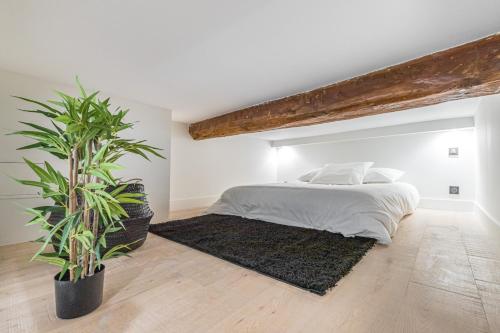 - une chambre avec un lit et deux plantes en pot dans l'établissement 12 BUNICO - Studio Duplex - Vieux Nice - 100m de la mer, à Nice